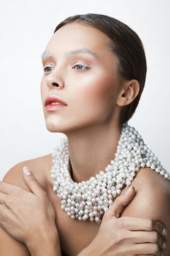 Beauty portrait of women with pearl necklace. White and col make