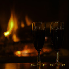 glasses of red champagne  by the fireplace