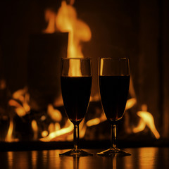 glasses of red champagne  by the fireplace