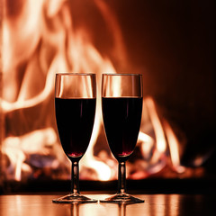 glasses of red champagne  by the fireplace