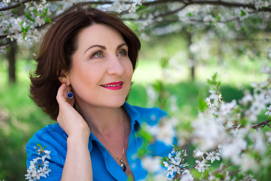 close up portrait of middle aged woman posing in cherry garden