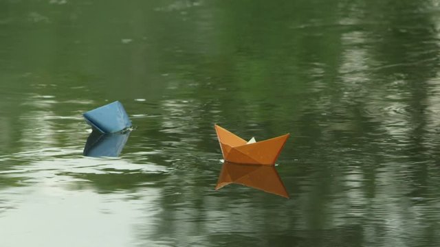 Two paper boats adrift in the river