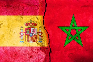 A large crack in the wall. Flag of Spain. Flag of Morocco
