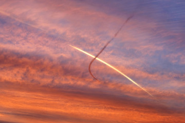 Fototapeta na wymiar Sunset sky with crossed plane traces