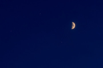 Obraz na płótnie Canvas half moon and small stars on a blue night sky