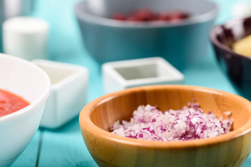 Chopped Red Onions And Food Ingredients On Turquoise Kitchen Table