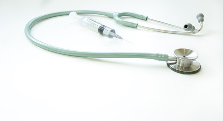 Stethoscope and plastic medical syringes on white background