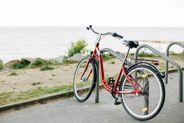 Naklejka na ściany i meble Bicycle parked on the bike parking near sea.