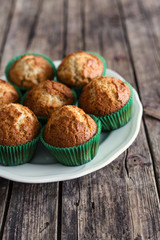 Muffins with yogurt on wooden background
