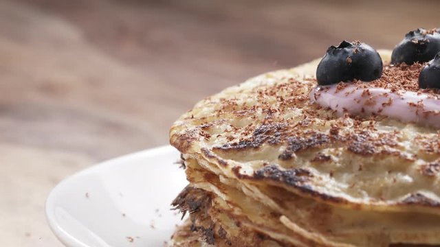 Slow motion of grating fine chocolate on blinis with yogurt and blueberries, 180fps prores footage