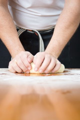 Man kneading dough on flour covered table