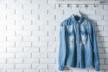 Denim shirt hanging on brick wall