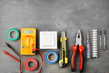 Different electrical tools on grey background