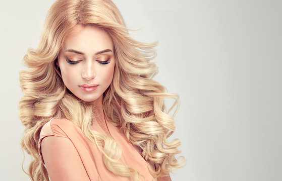 Beautiful girl blonde hair with an elegant hairstyle , hair wave ,curly hairstyle . 