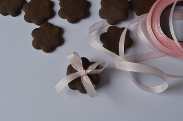 Homemade dark chocolate flower shaped cookies with pale pink ribbon bow