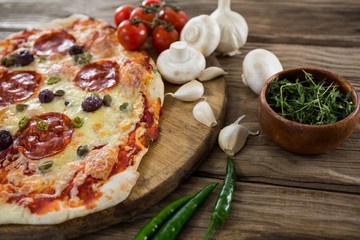 Various species with pizza and tomato on a wooden tray