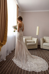 Fototapeta premium Elegant bride in wedding dress with long plume