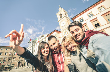 Group of cool multiculture tourists friends having fun taking selfie in old town tour - Travel...