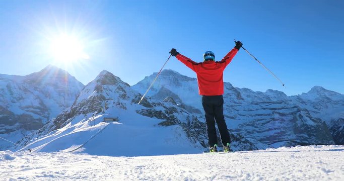 Happy Skier skiing and enjoying the sunny weather in Swiss Alps under Jungfrau, Monch and Eiger peaks