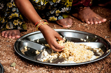 Little girl hands eating at school - India 
