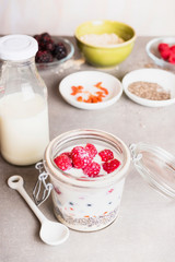Healthy breakfast glass preparation with : milk, oatmeal , Chia seeds, Goji berries, fresh berries