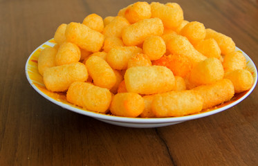 Corn sticks in bowl on wooden table