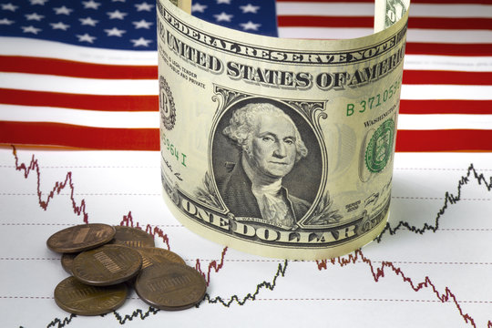 Stock market prices chart. Black and red lines of prices on the chart. Heap of one cent us coins near rolled one us dollar bill. USA flag as a background. Close up image.Stock exchange concept.