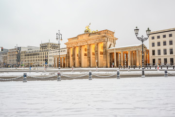 illuminated Brandenburg gate (Brandenburger Tor) and 18th of March Square in snow, Berlin, Germany,...