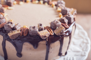 Decorated chocolate and pecan cake close up with chocolate ganache and cream cheese frosting, selective focus