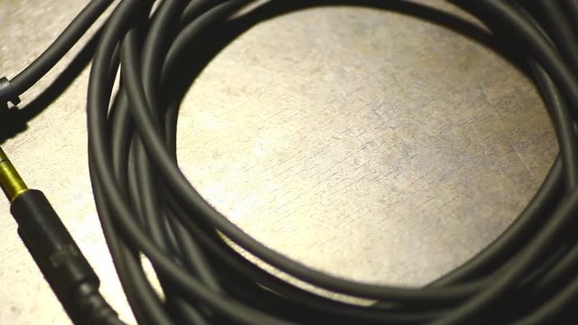 Close up dolly video of a a rolled up cable with jacks.