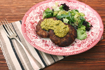 Fried beef patties with pesto sauce and greens. Healthy eating concept.