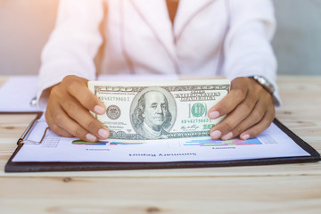 Business woman gripping The United States hundred-dollar bills i