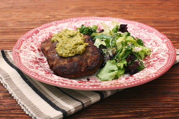 Fried beef patties with pesto sauce and greens. Healthy eating concept.