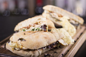 Tasty grilled sandwiches with on a wooden plate. Beautifully served meal at the restaurant.