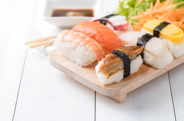 sushi with sauce and wasabi on wood plate