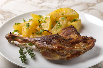 Roast duck with golden potatoes and herbs on plate