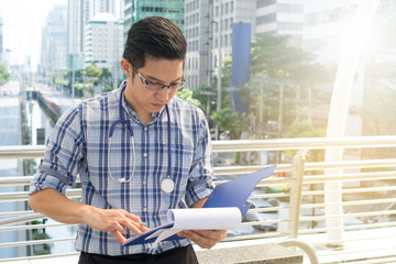 Doctor in the shirt with stethoscope writing the patient chart a
