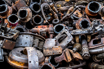 Pile of Used machine parts are oily and rusty in second hand machinery shop.