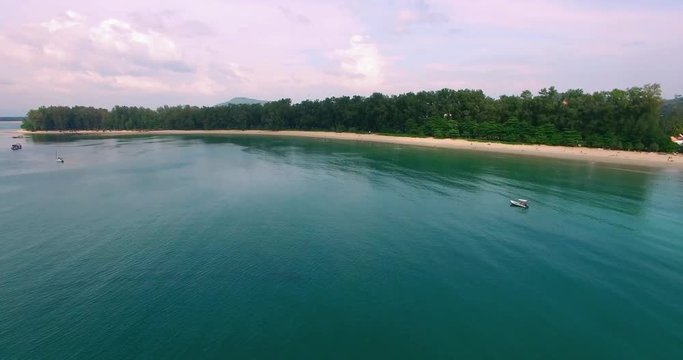 Aerial footage. Flying close over tropical sandy beach and waves. Thailand. Phuket. Layan beach. 4K