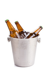cold bottles of beer in bucket with ice on white background.