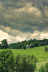 Obraz premium Hills covered with green grass under blue sky