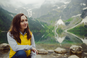 Naklejka premium woman relaxing on the lake and mountains sunny landscape