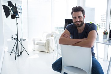 Happy male photographer sitting in studio