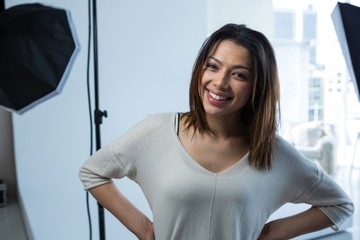 Happy female photographer standing in studio
