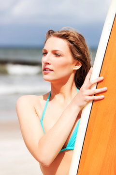 Surfer girl on the beach in bikini.