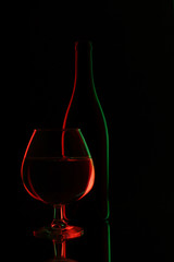 glass bottle of wine and wineglass on black background