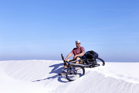 Traveling man on a bicycle in the desert.