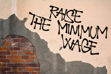 Raise The Minimum Wage - Handwritten graffiti sprayed on the wall - appeal to increase salary and...