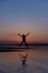 Silhouette of man jumping during sunset