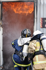 Naklejka premium Firemen enters burning building